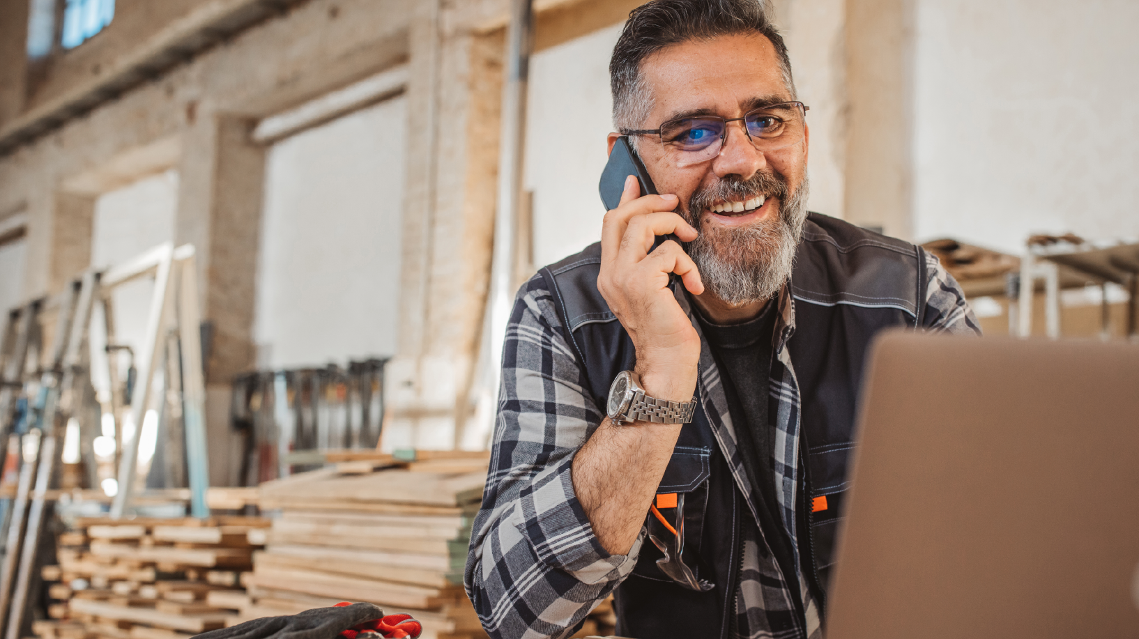 Carpenter working in shop on laptop