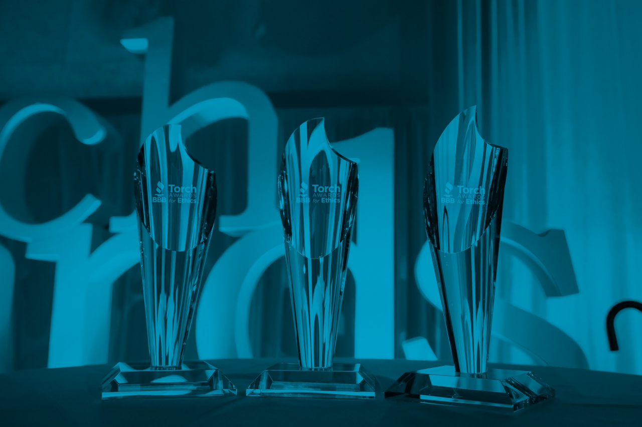 BBB Torch Awards for Ethics logo blue on blue faded background