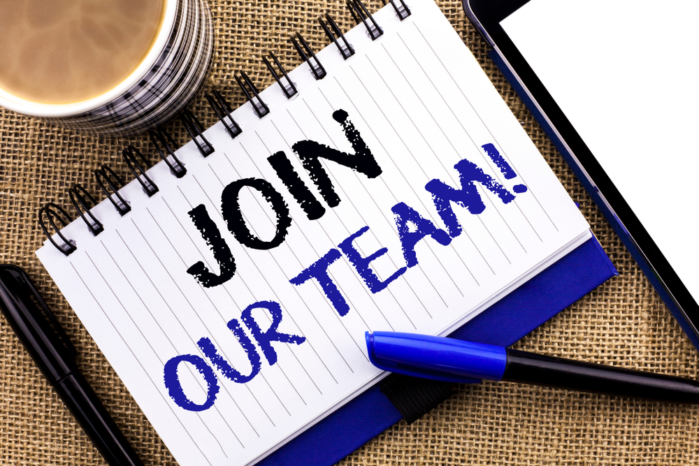 Text sign showing Join Our Team Motivational Call. Conceptual photo Invitation to Work Together Job Offer written Notebook Book the jute background Tablet Coffee Cup and Pens next to it