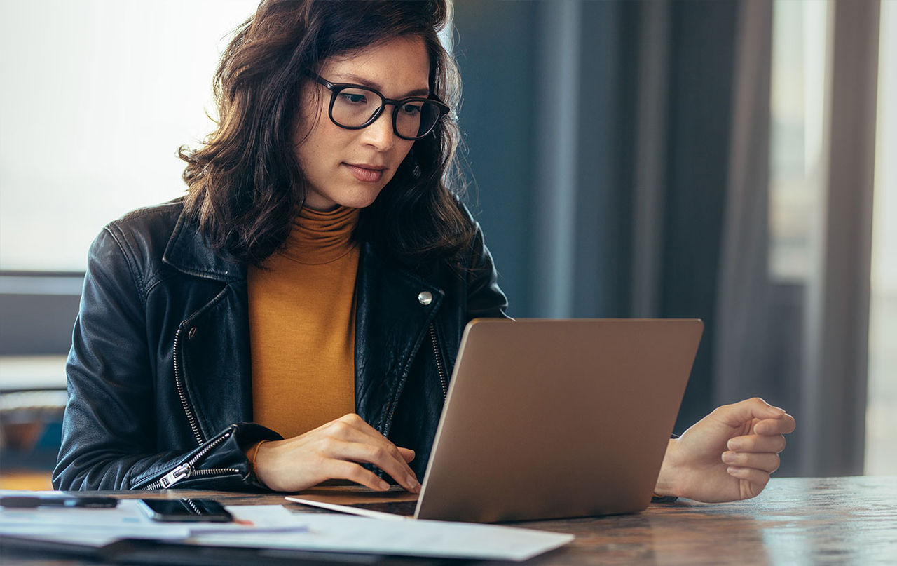 Woman viewing her laptop while sitting at desk