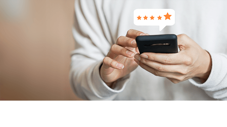 Person holding phone with 5 stars review bubble