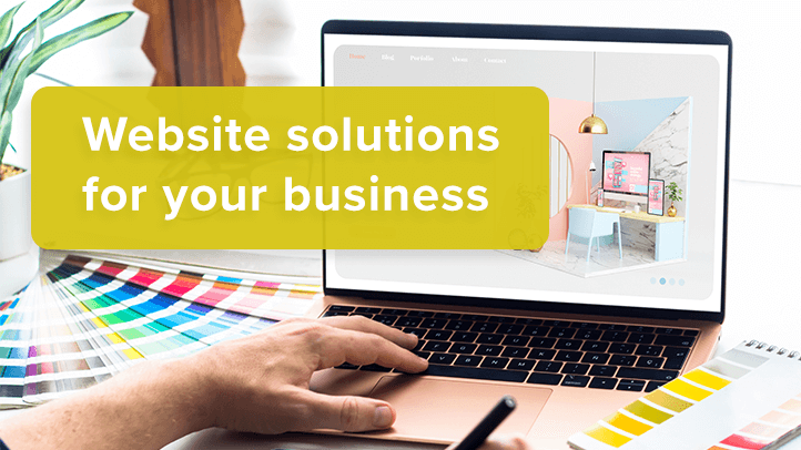 Person's hand working at laptop on website design with text "website solutions for your business"