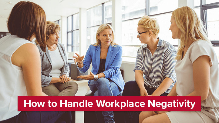 Group of women sitting in circle having serious conversation with text  "How to handle workplace negativity"