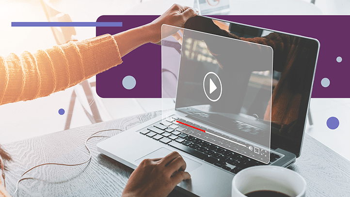 Person sitting at table with coffee and laptop looking at video