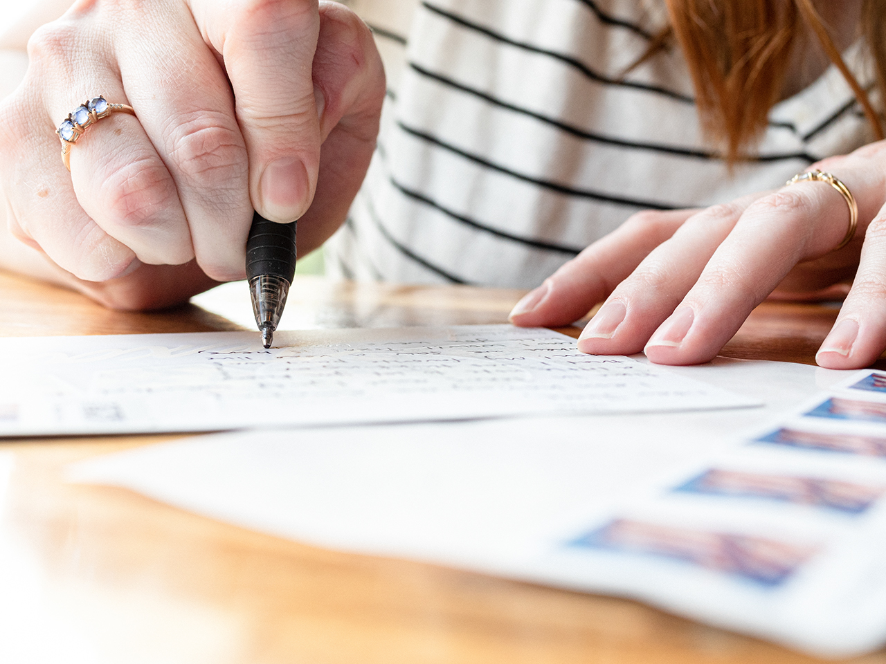 Woman writing on a postcard