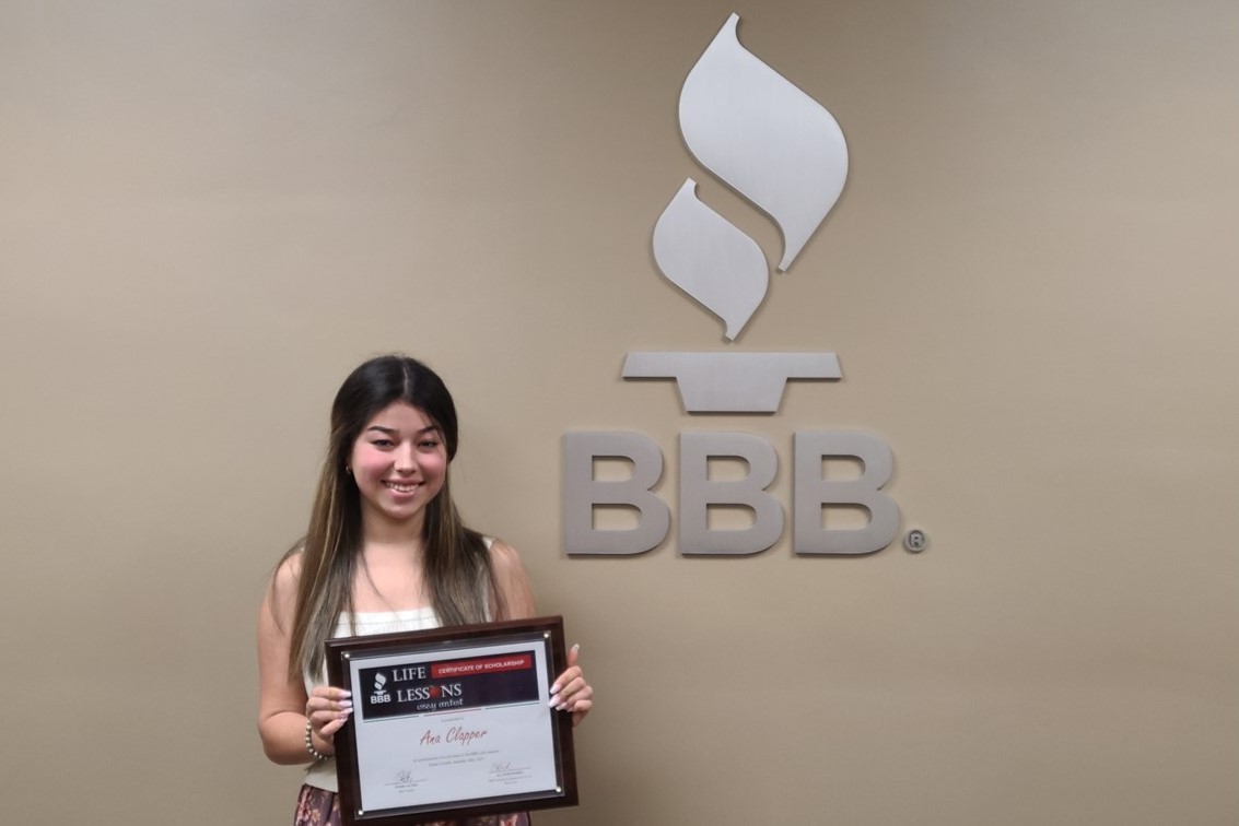 Ana Clapper 2021 4th place winner holding award plaque next to BBB sign