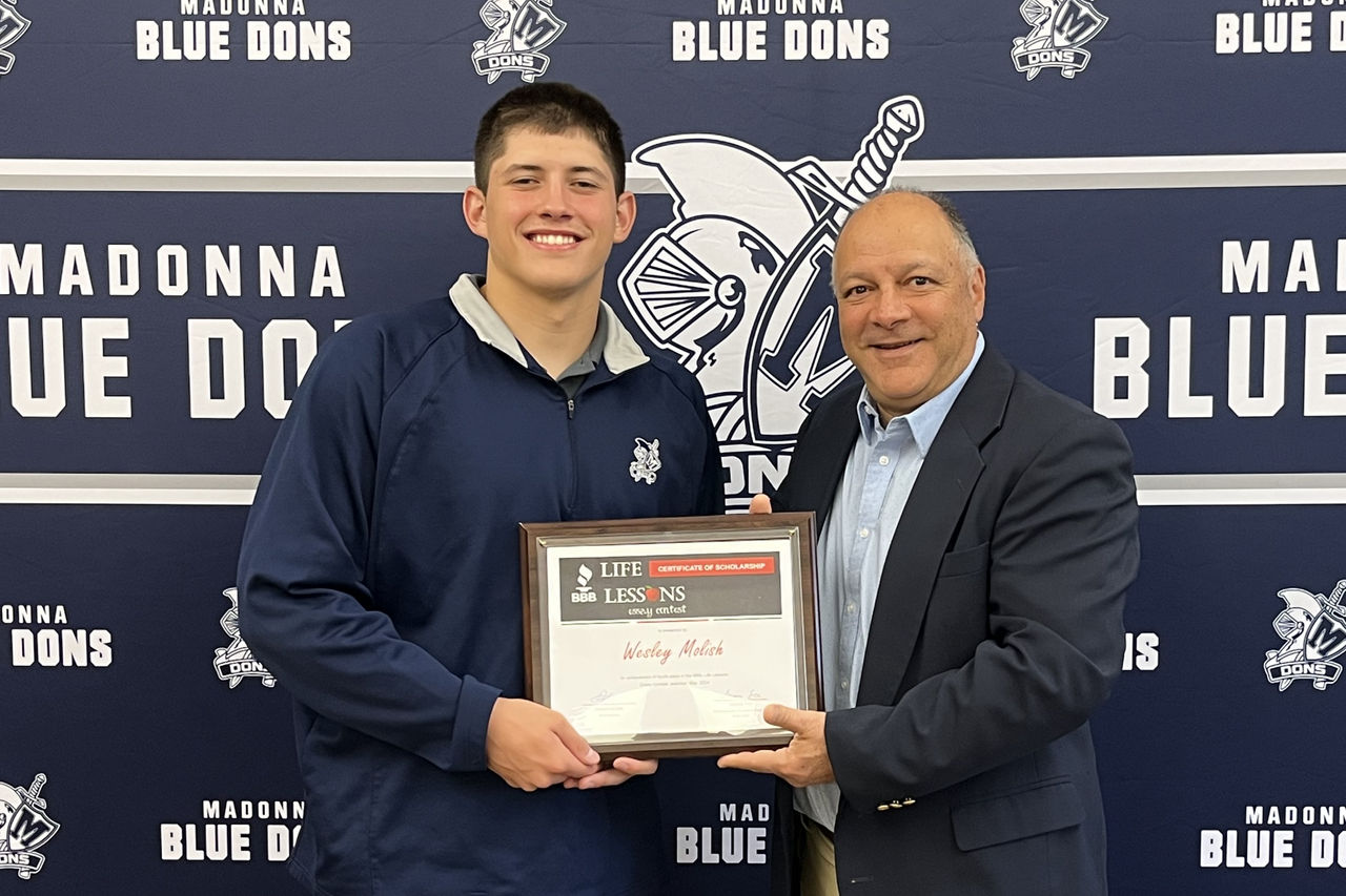 Wesley Molish receiving scholarship award certificate from BBB CEO Frank Cilona