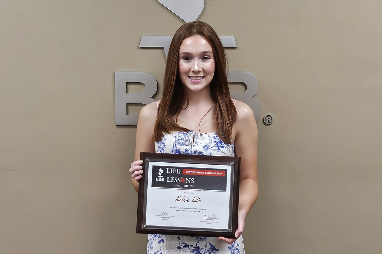 Kelsie Edie holding scholarship award certificate