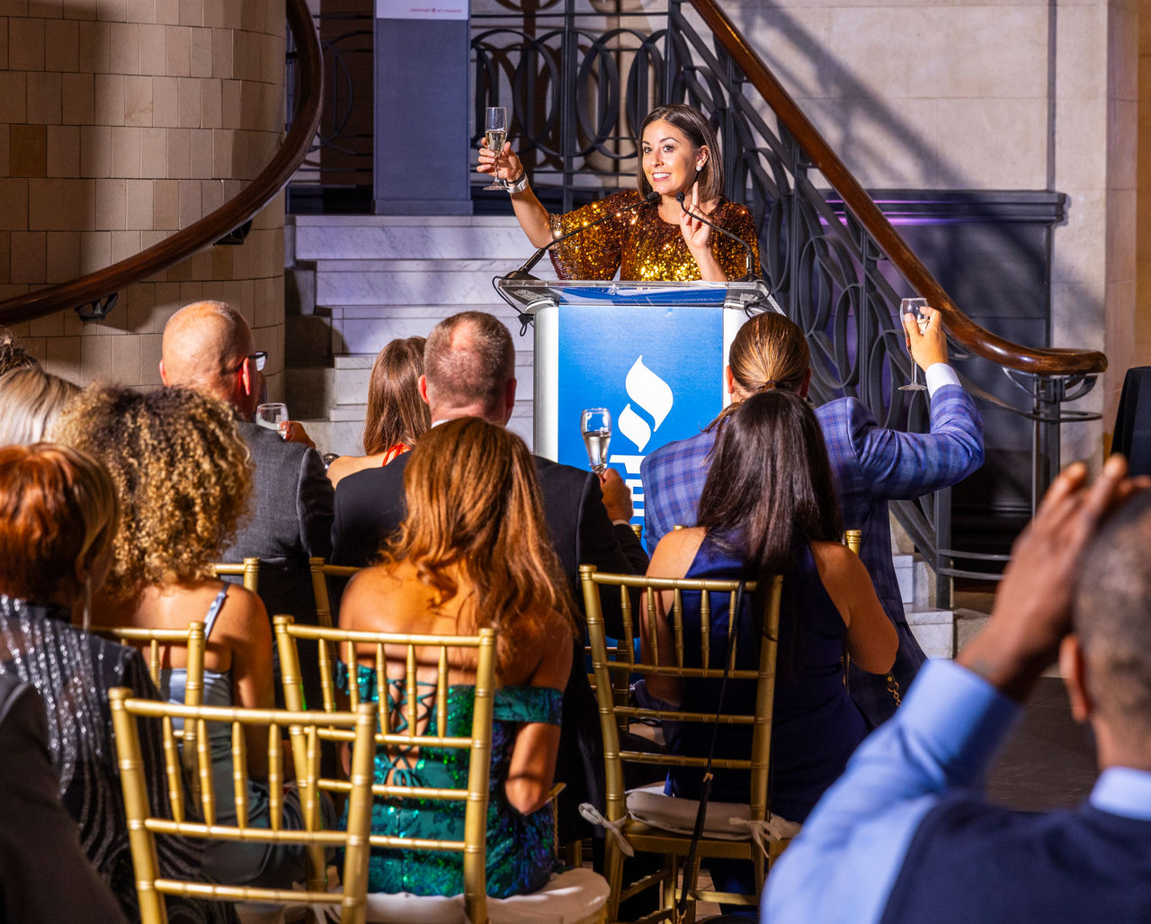 Event emcee Cassy Arsenault, Local 12, raises a toast to the 2023 BBB Torch and Spark Awards winners with event guests.