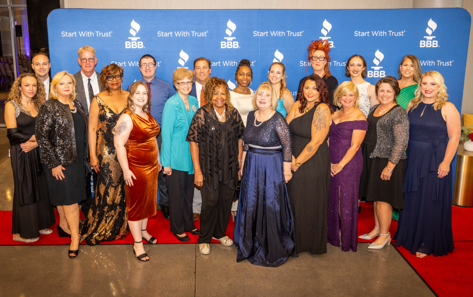 Picture of large group of people in formalwear on a red carpet in front of BBB backdrop