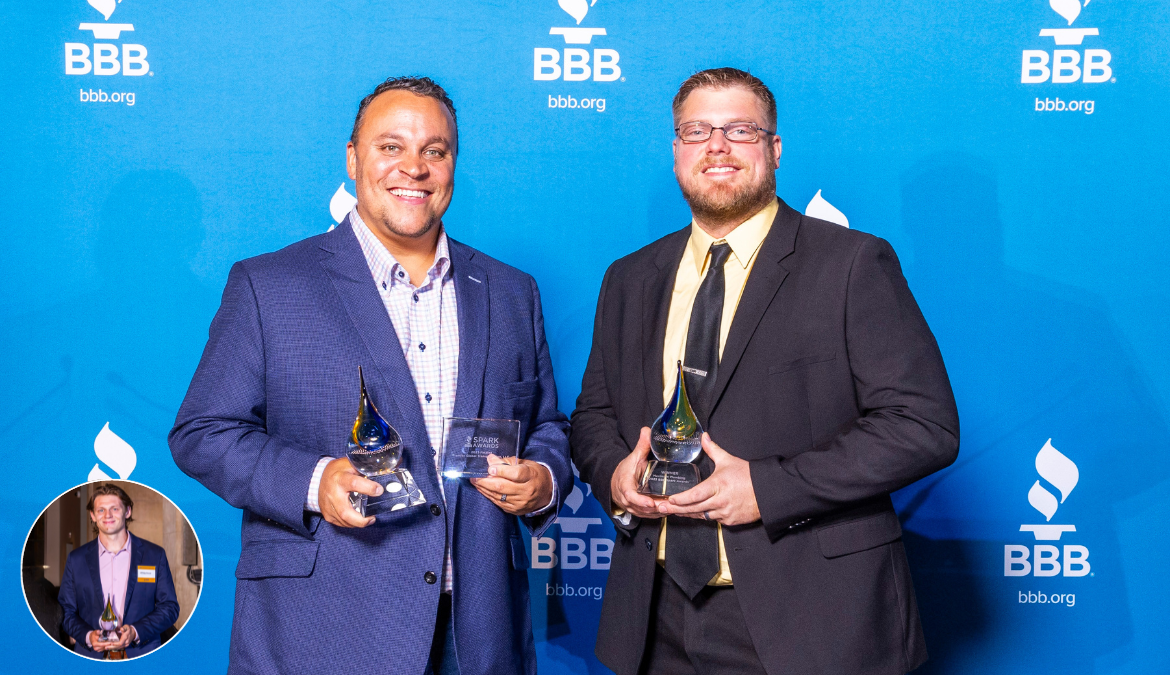 Two 2023 Spark Awards winners with trophies on a stage in front of a blue BBB backdrop with a small circle and headshot one other winner in the bottom right corner.