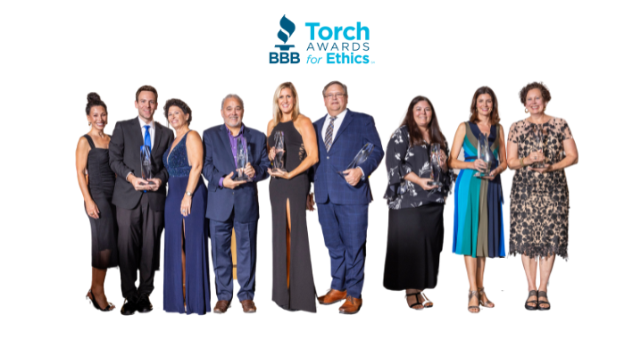 Nine 2024 Torch Awards for Ethics winners with trophies on a white background