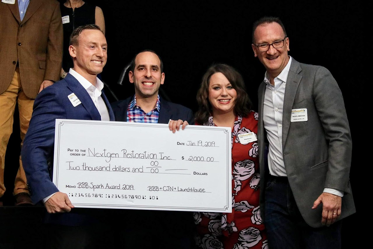 Picture of Todd Goldstein of LaunchHouse, Pam Anson of BBB Serving Greater Cleveland, and Kevin Adelstein of Cleveland Jewish News presenting an oversized check for $2,000 to 2019 Spark Award Winner, NextGen Restoration