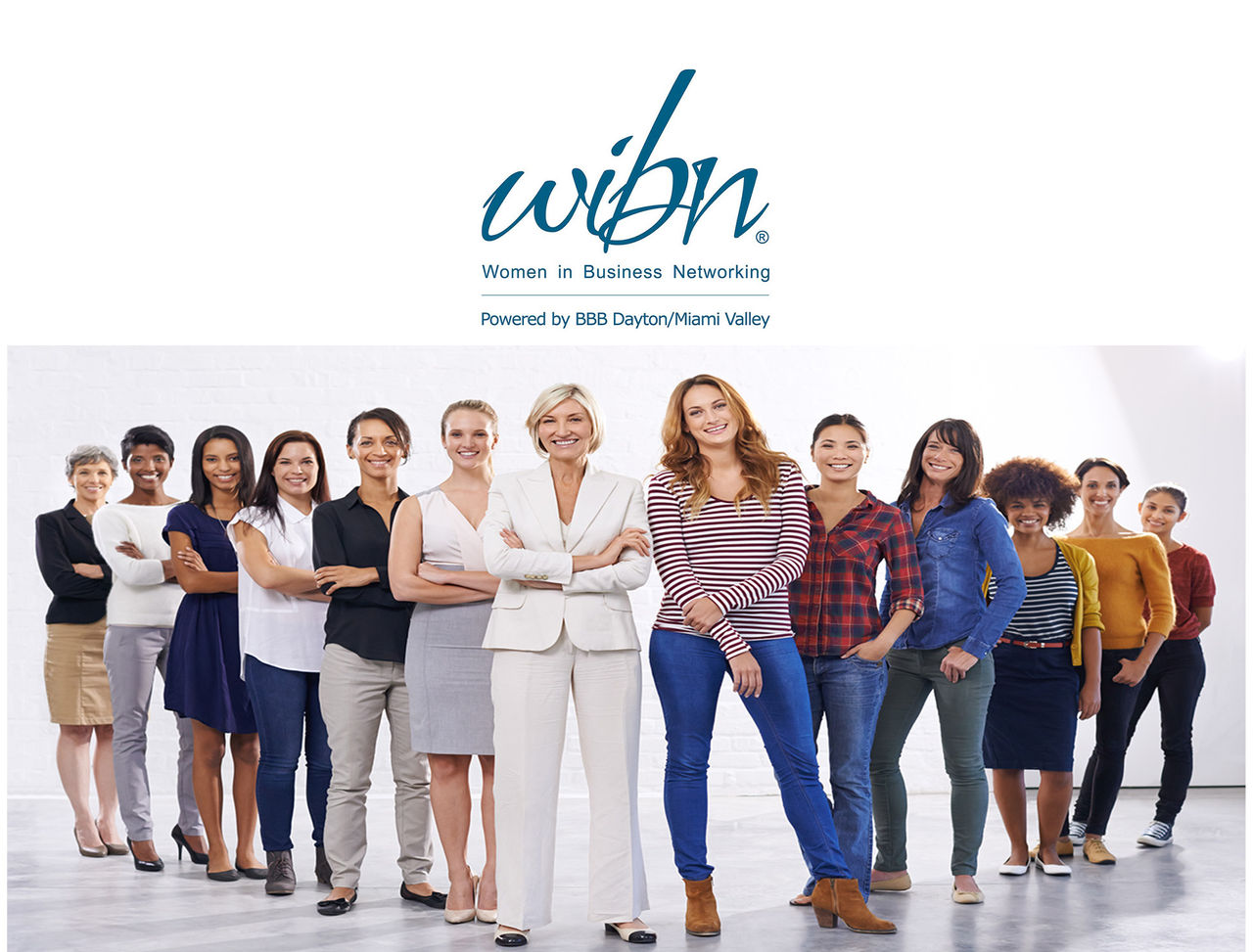 large group of women in business attire smiling