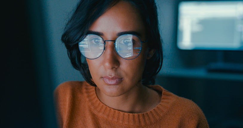 Female computer programmer works on complex software development tasks at her home office late into the night. Software developer, artificial intelligence and programming concept.