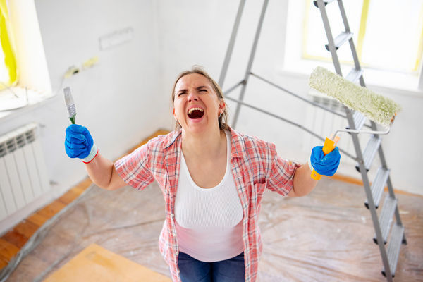 Tired, exhausted, stressed woman doing a home renovation. A woman faces many problems and difficulties in repairing?