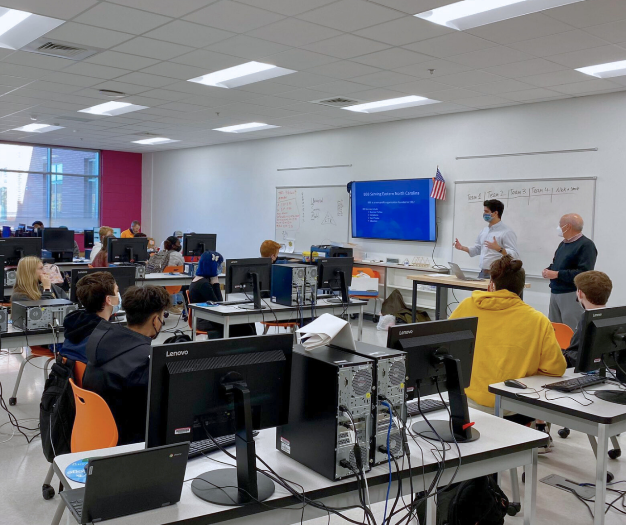 BBB employees in a classroom conducting a Scambusters presentation.