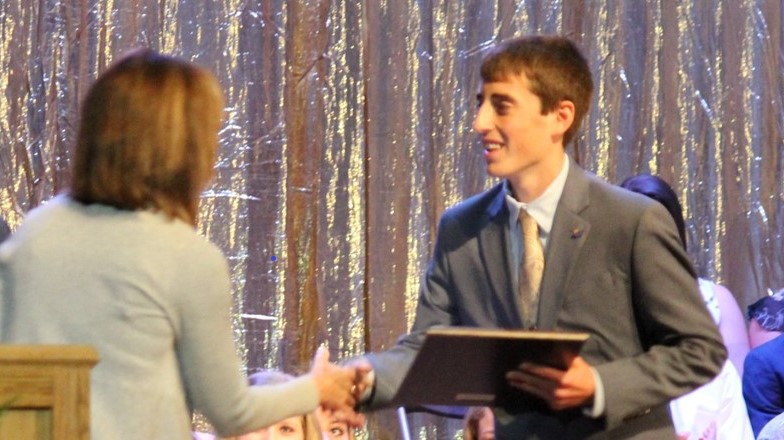 male student receiving scholarship