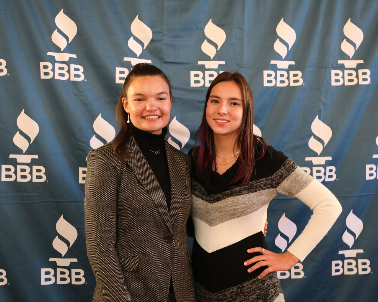 Two high school students posing for picture in front of award table