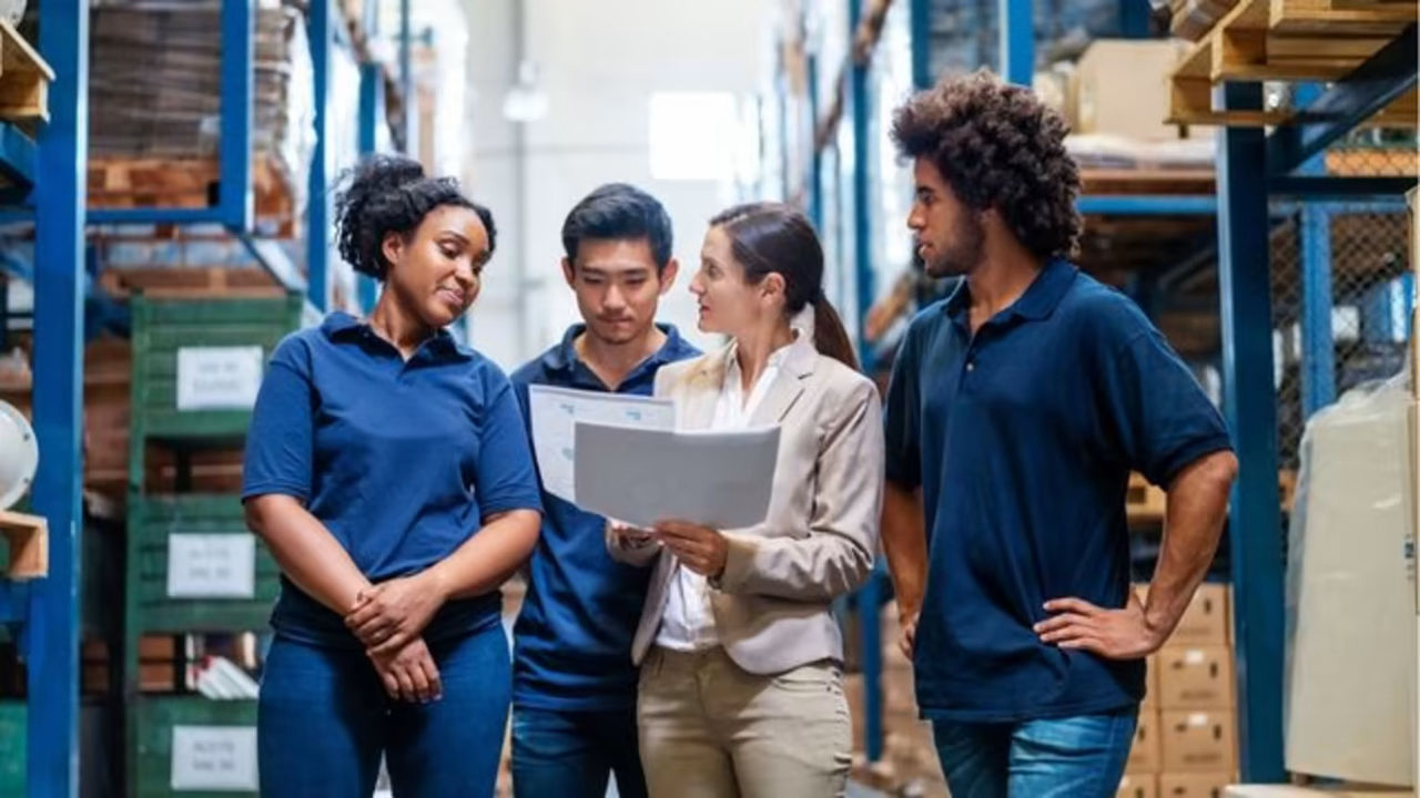 Warehouse workers reviewing report with manager