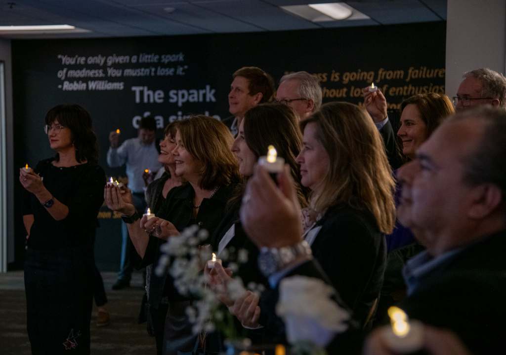 Group of people holding lit candles in Ignite Center