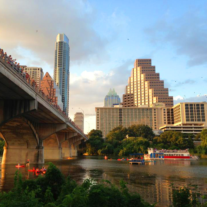 Photo of famous bridge in Austin, Texas, where bats are flying out during sunset.