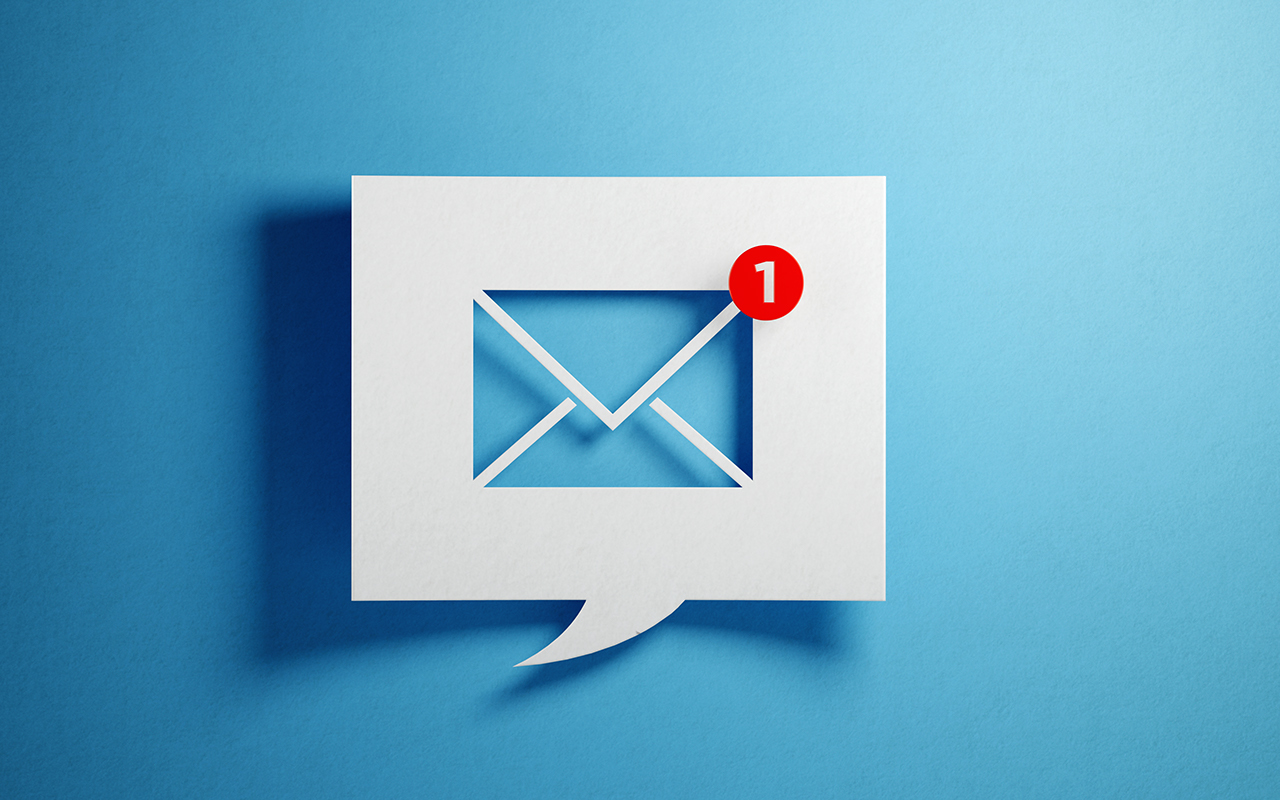 White chat bubble with email symbol on blue background. Horizontal composition with copy space.