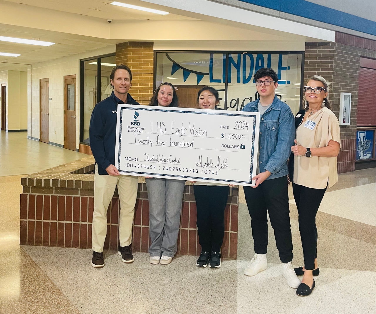 Local student standing with 1st place winner check