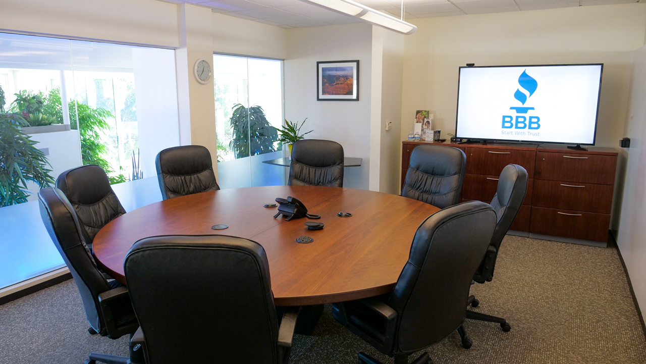 room with circular table in the middle and large screen television in the corner