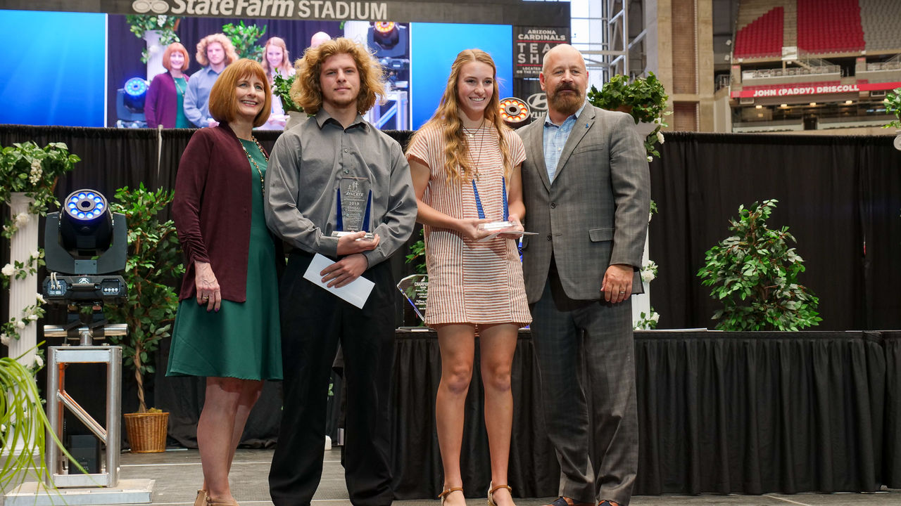 Posing with two high school student scholarship winners at award ceremony in State Farm Stadium