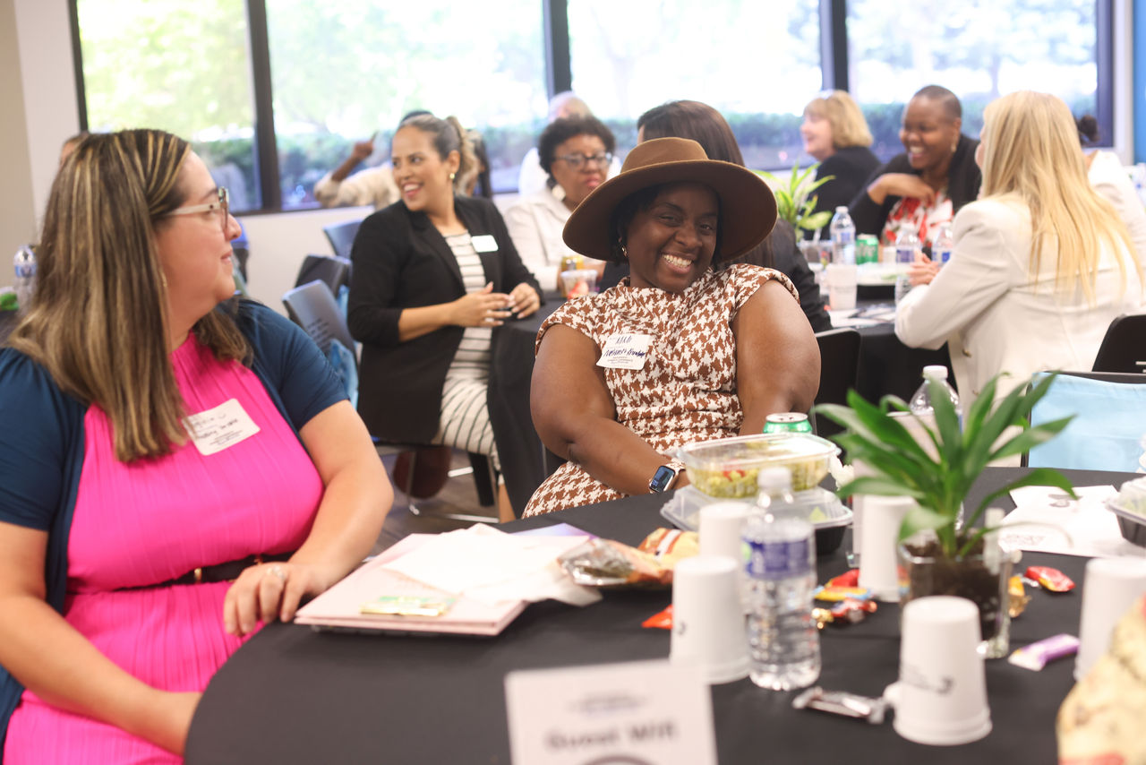 Conference goers smiling and networking at the Sacramento Women's Conference