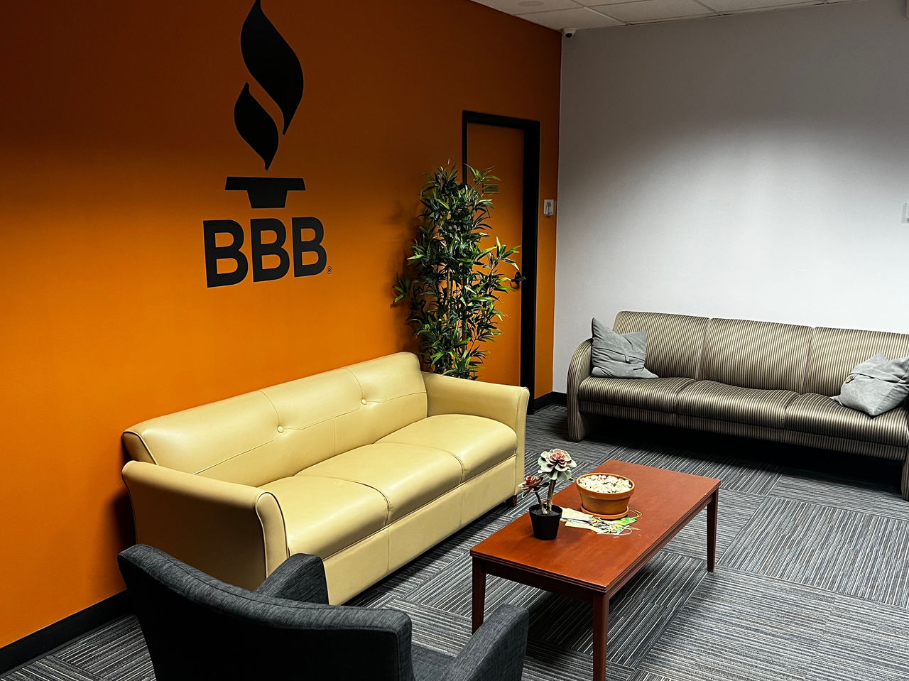 View of Torch Center, burnt orange wall with BBB logo and furniture set